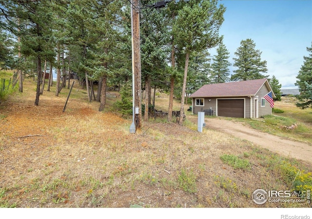 view of yard featuring a garage and an outdoor structure