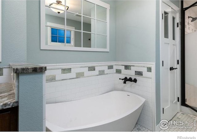 bathroom featuring vanity, tile walls, and a bathtub