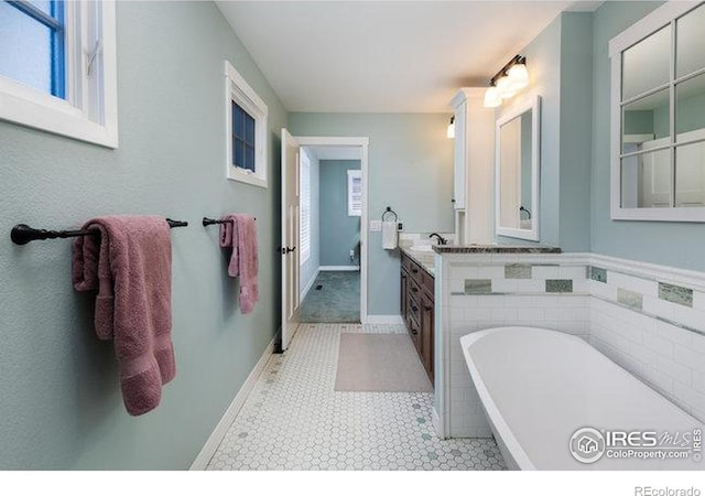 bathroom with vanity and a tub to relax in