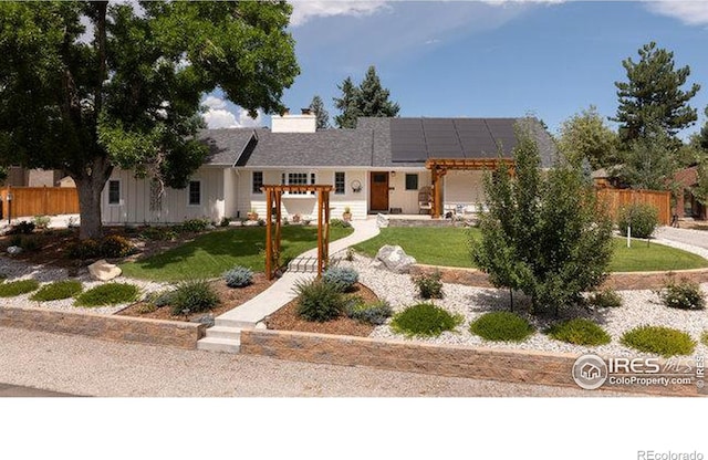 ranch-style house with a pergola, a front yard, and solar panels