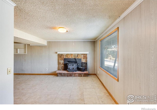 unfurnished living room with crown molding, tile patterned floors, a textured ceiling, and a wood stove