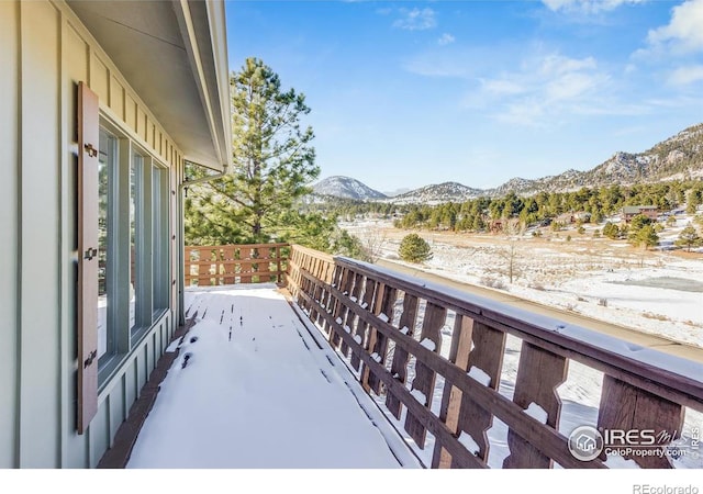 snow covered back of property with a mountain view