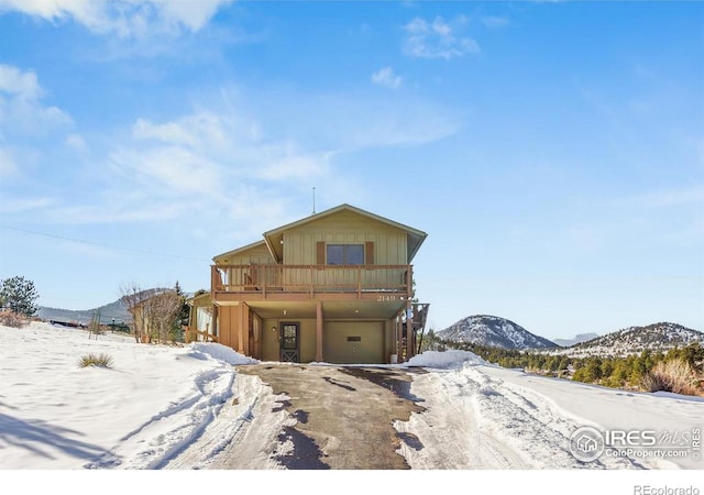 view of front of property with a garage and a deck with mountain view