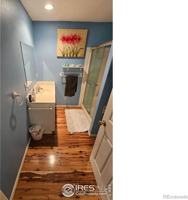 bathroom featuring hardwood / wood-style flooring, vanity, and an enclosed shower