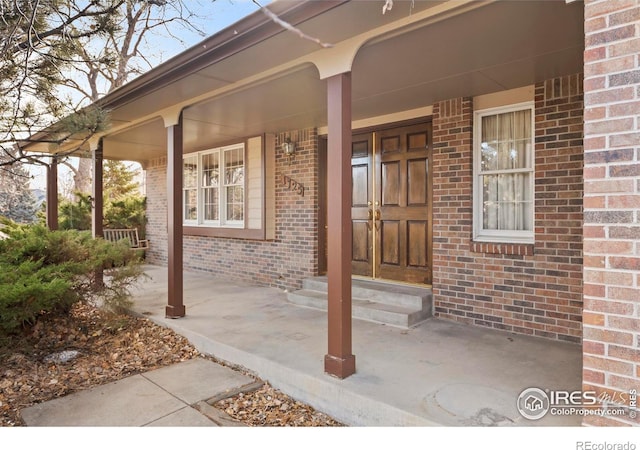 view of exterior entry featuring covered porch