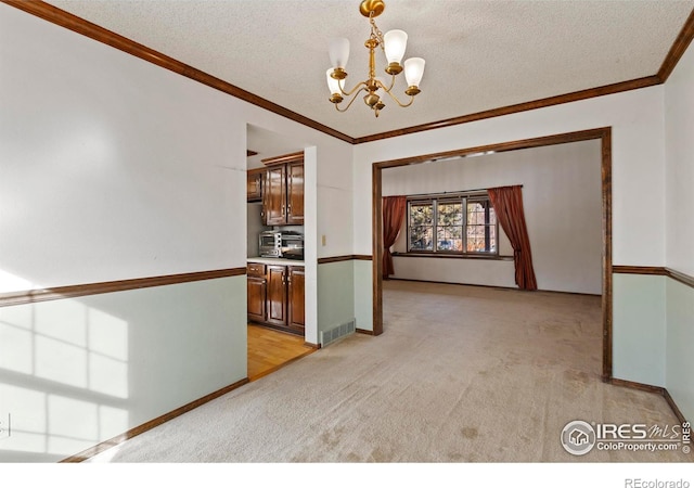 interior space with a textured ceiling, ornamental molding, and a chandelier