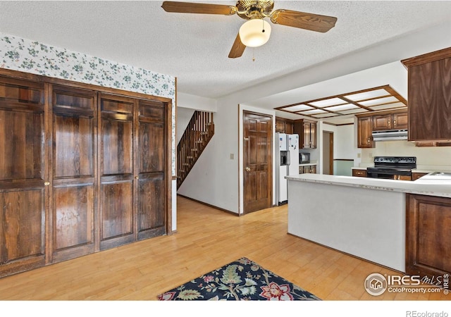 kitchen with ceiling fan, a textured ceiling, light wood-type flooring, and black appliances