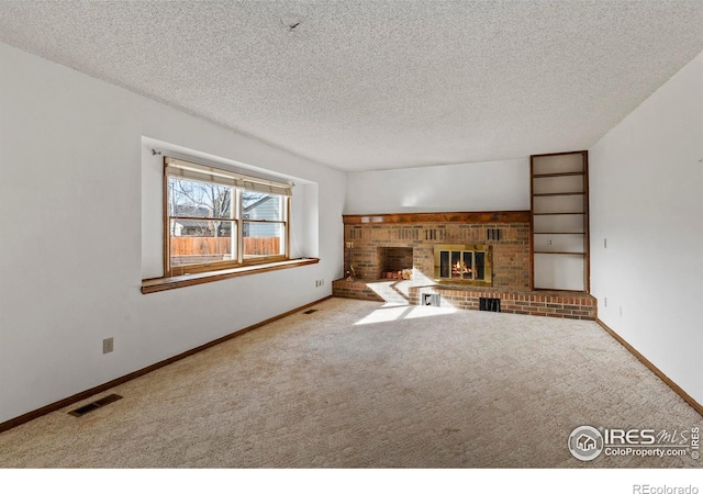 unfurnished living room featuring a fireplace, carpet floors, and a textured ceiling