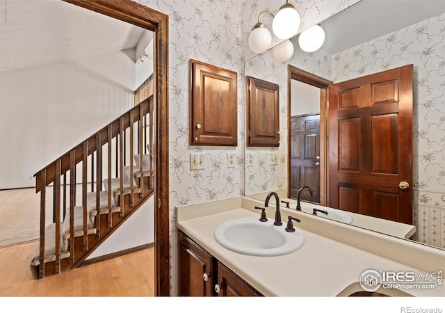 bathroom with vanity, a chandelier, and wood-type flooring