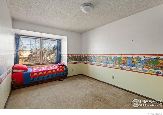 bedroom featuring carpet flooring and a textured ceiling