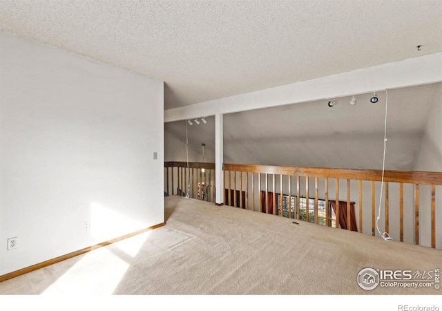 carpeted spare room with a textured ceiling