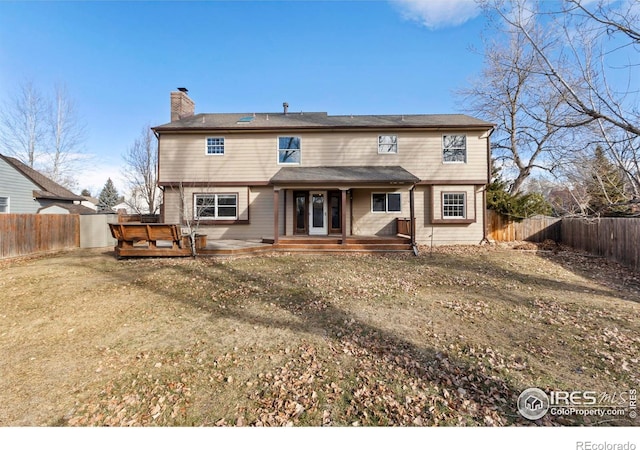 rear view of property with a yard and a hot tub