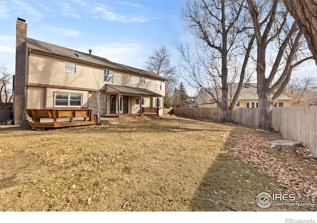 rear view of property with a yard, cooling unit, and a deck