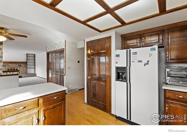 kitchen featuring light hardwood / wood-style flooring, white refrigerator with ice dispenser, and ceiling fan