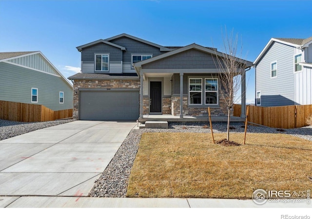 craftsman-style home featuring driveway, a garage, stone siding, fence, and a porch