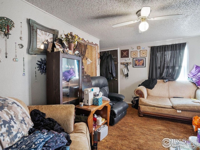 living room featuring ceiling fan, carpet flooring, and a textured ceiling