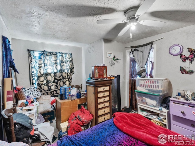 bedroom with ceiling fan and a textured ceiling