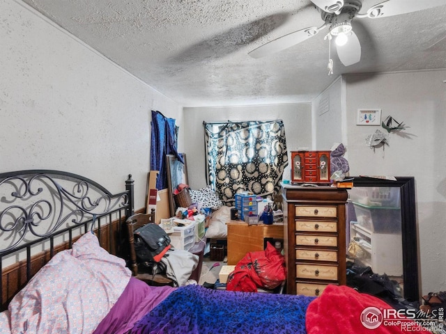 bedroom featuring ceiling fan and a textured ceiling