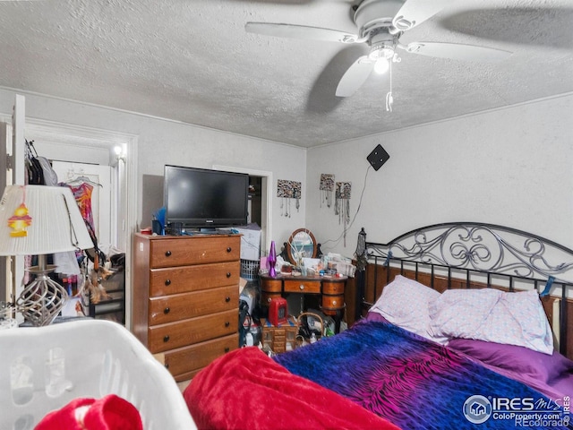 bedroom featuring ceiling fan and a textured ceiling