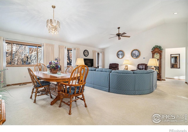 carpeted dining space featuring ceiling fan with notable chandelier and vaulted ceiling