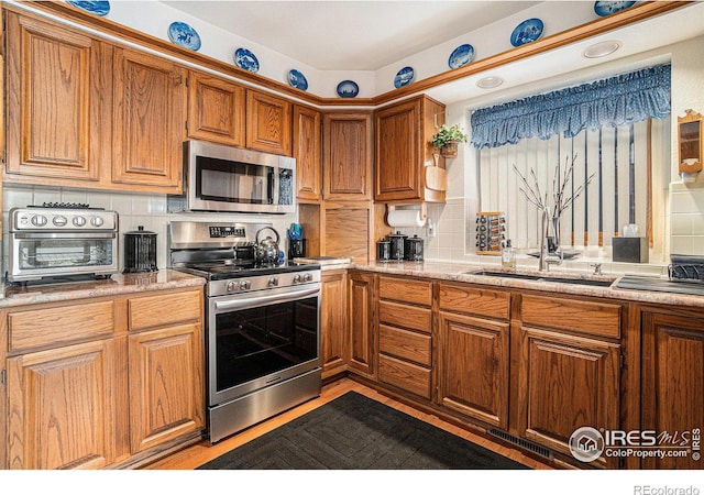 kitchen with stainless steel appliances, backsplash, and light stone counters