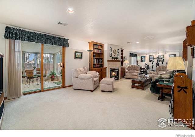 living room with carpet flooring and a tiled fireplace