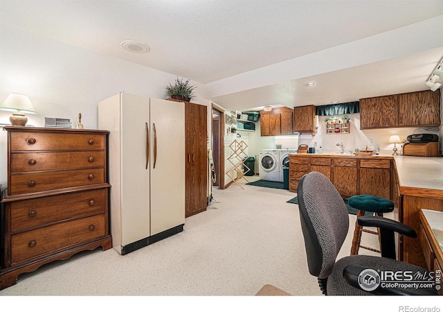 kitchen featuring washing machine and clothes dryer and refrigerator