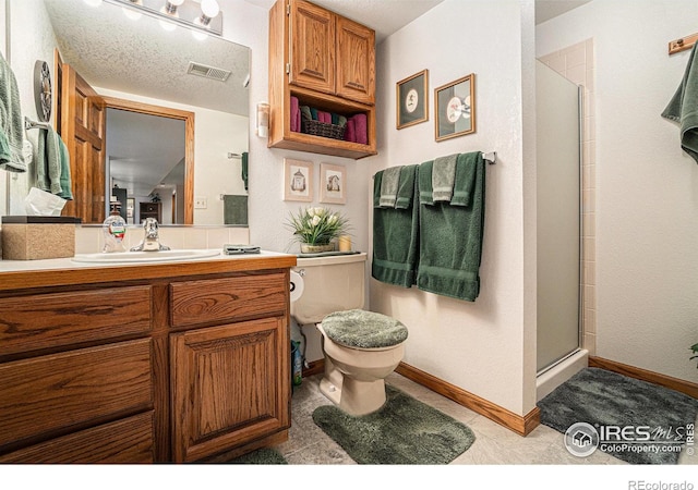 bathroom with an enclosed shower, vanity, toilet, and a textured ceiling