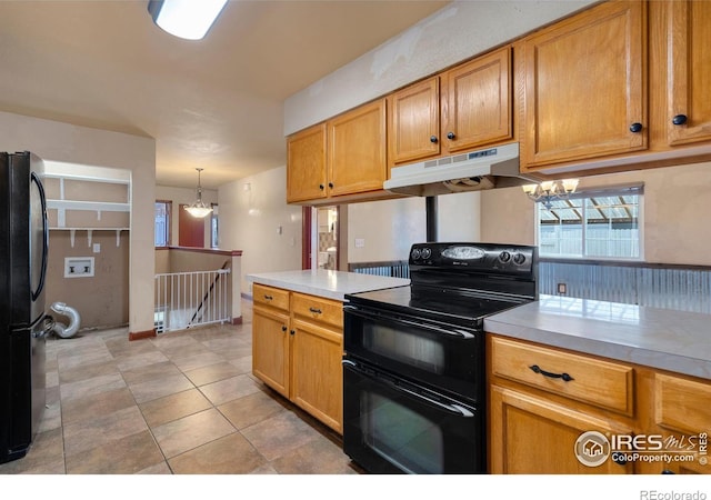 kitchen featuring an inviting chandelier, decorative light fixtures, light tile patterned flooring, and black appliances