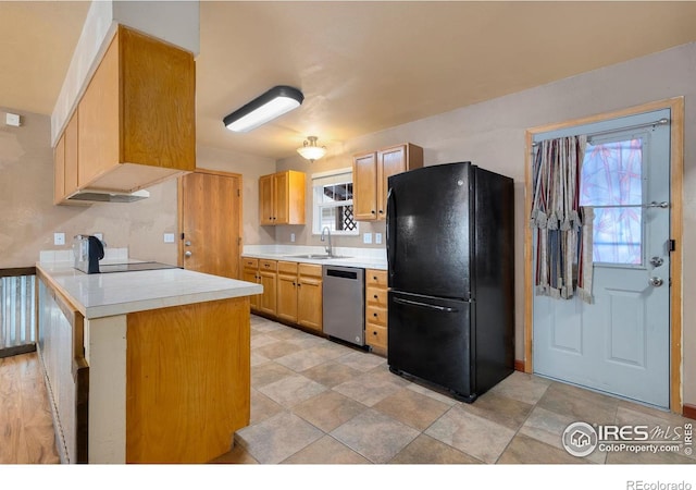 kitchen with sink, dishwasher, black refrigerator, stove, and kitchen peninsula