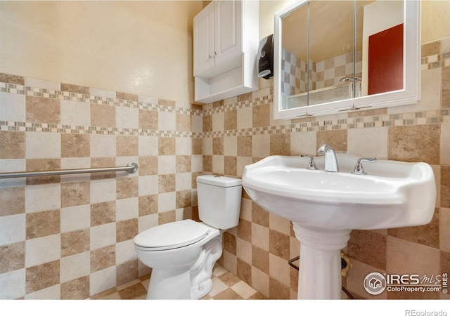 bathroom with tile walls and toilet