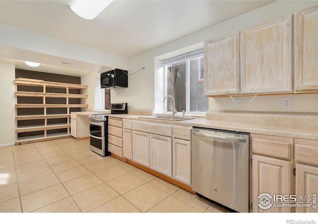 kitchen featuring light tile patterned flooring, appliances with stainless steel finishes, sink, and light brown cabinets