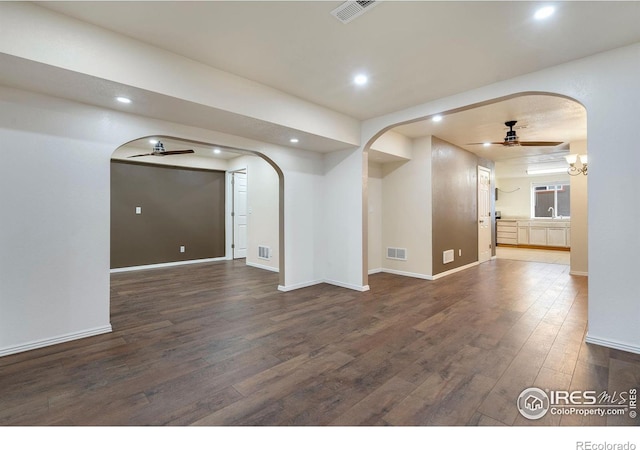 empty room with dark wood-type flooring and ceiling fan