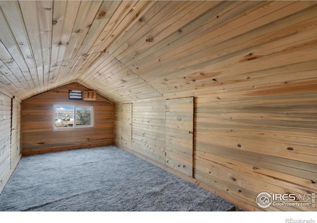 additional living space with vaulted ceiling, carpet floors, wooden ceiling, and wood walls