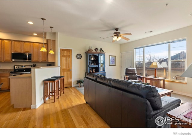 living room with light hardwood / wood-style floors and ceiling fan