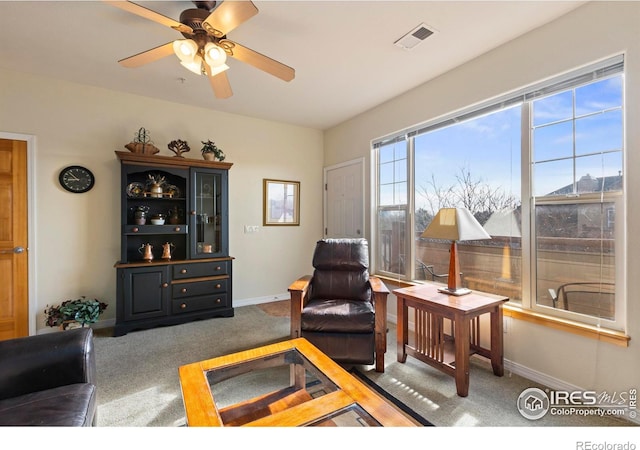 carpeted living room with ceiling fan