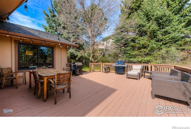 wooden terrace with a grill and outdoor dining space