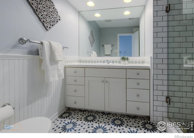 bathroom with toilet, recessed lighting, visible vents, vanity, and wainscoting