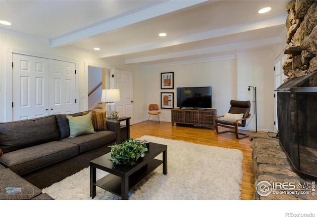 living area featuring beam ceiling, recessed lighting, stairway, ornamental molding, and wood finished floors