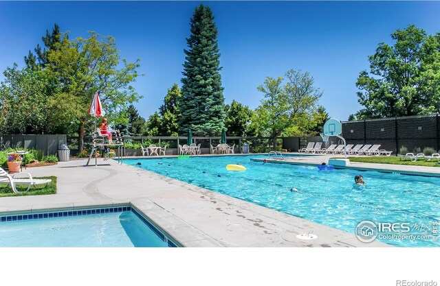 pool featuring fence and a patio