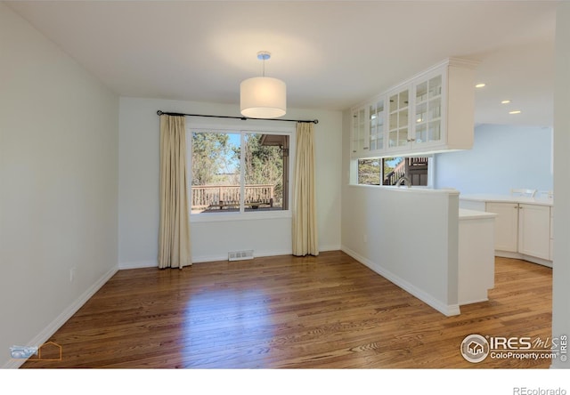 unfurnished dining area with recessed lighting, visible vents, light wood-style flooring, and baseboards