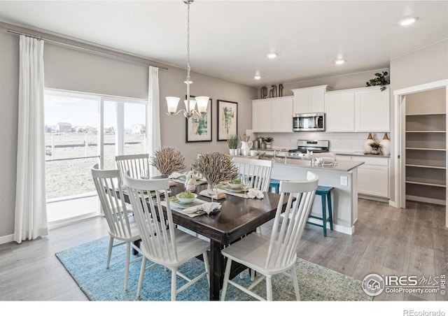 dining area featuring an inviting chandelier and light hardwood / wood-style floors