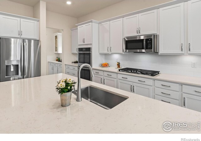 kitchen with white cabinetry, sink, and stainless steel appliances