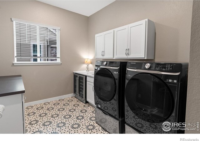 laundry area featuring cabinets, washing machine and clothes dryer, and wine cooler