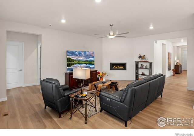 living room with ceiling fan and light hardwood / wood-style floors