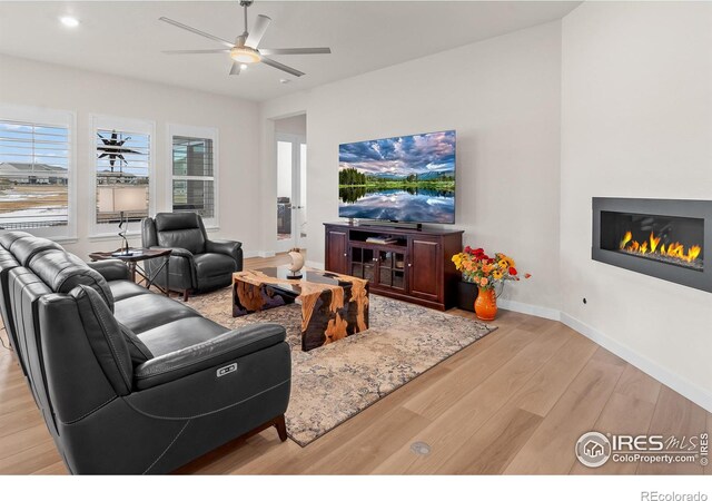 living room featuring light hardwood / wood-style floors and ceiling fan