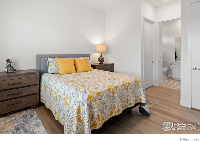 bedroom featuring ensuite bathroom and light hardwood / wood-style flooring