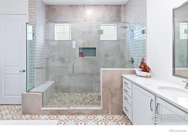 bathroom featuring walk in shower, a healthy amount of sunlight, and vanity