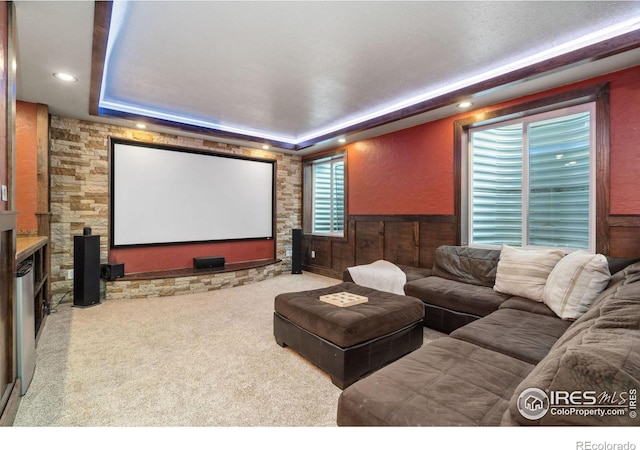 home theater with a tray ceiling and carpet flooring