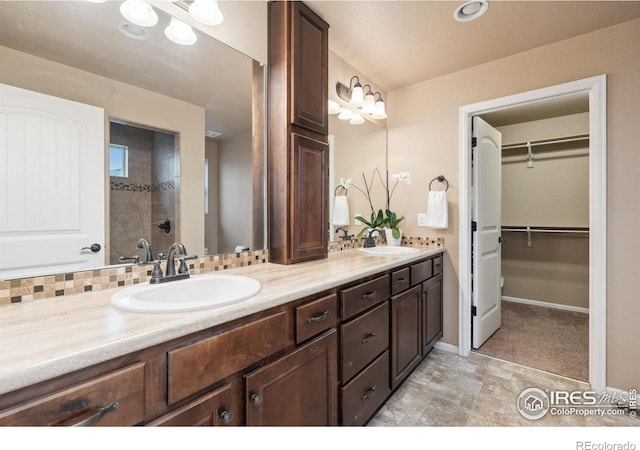 bathroom with vanity, decorative backsplash, and tiled shower